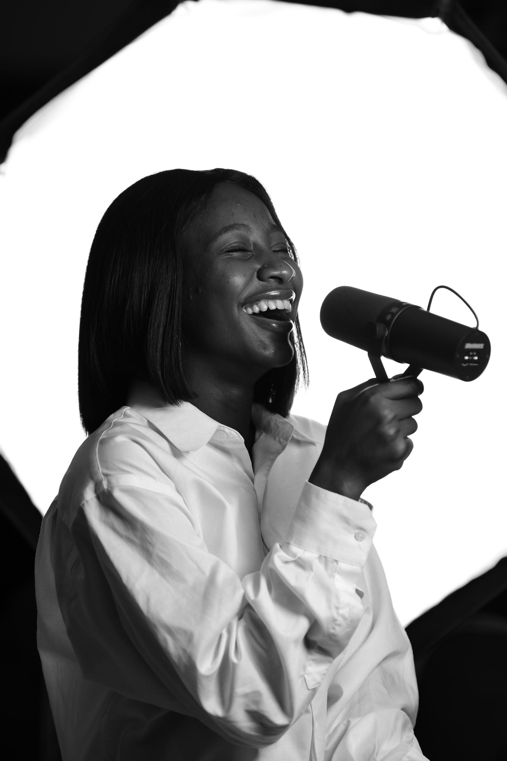 Mowa laughing while holding a microphone